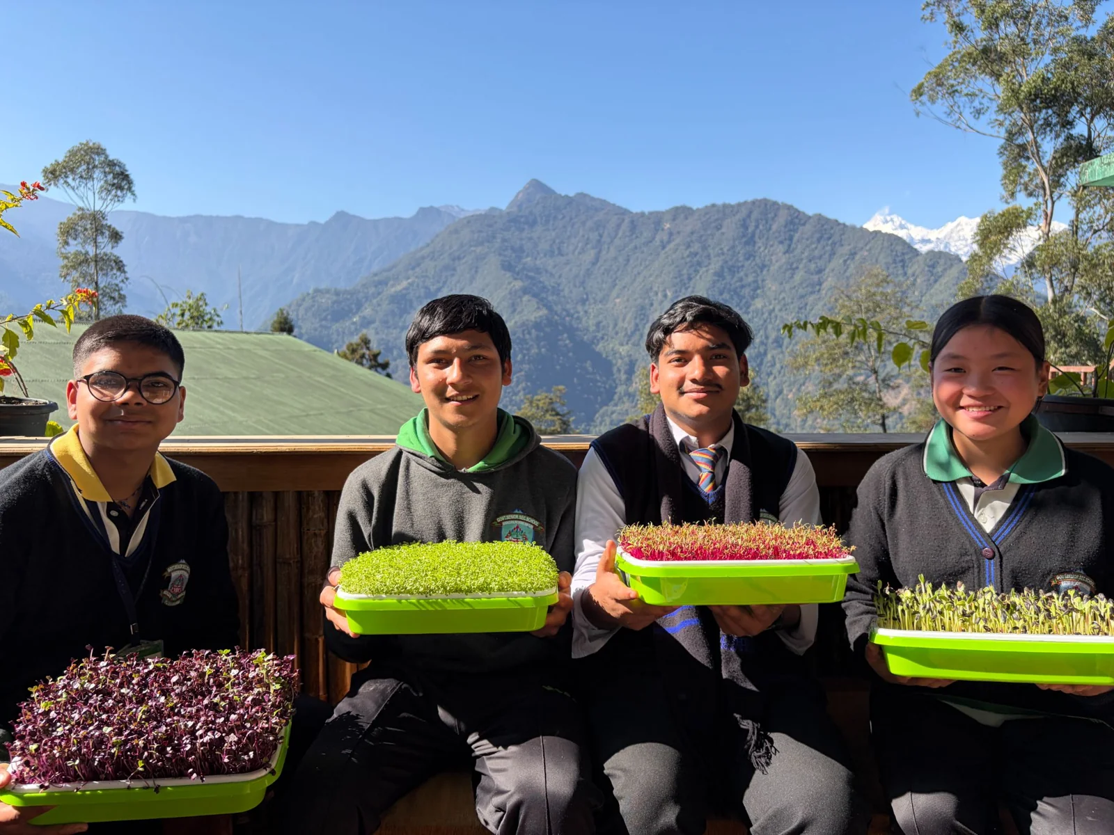 Students holding trays of microgreens in Sikkim